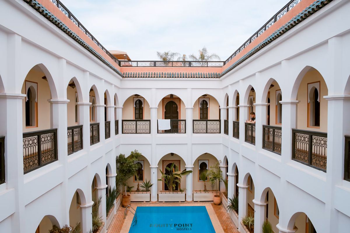 Weißer Innenhof eines Riads mit Arkaden und Pool